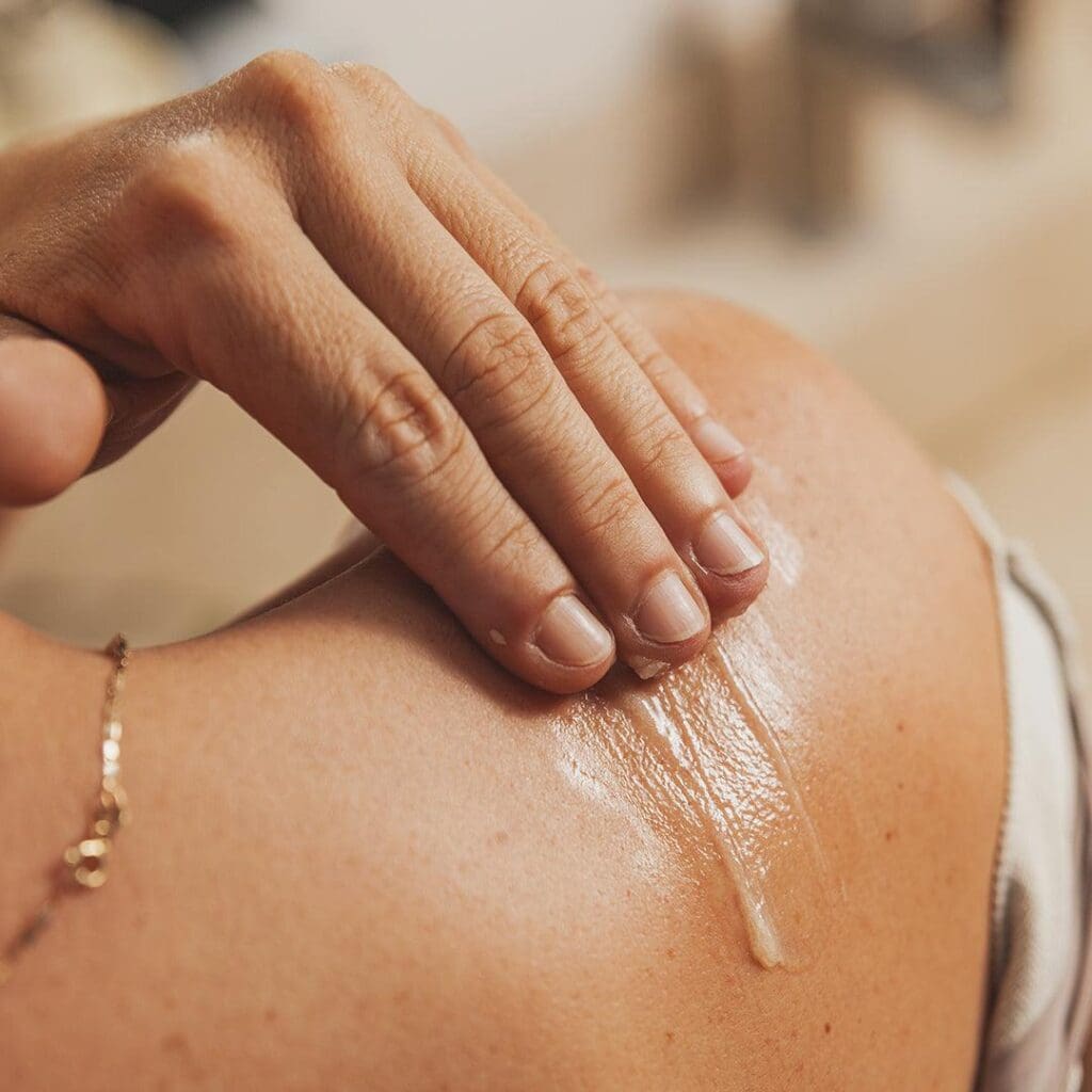 Massage therapist applying CBD topicals during bodywork